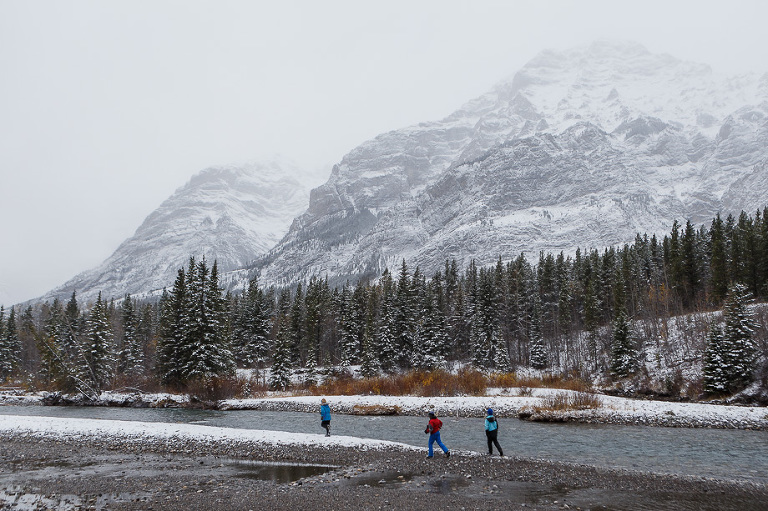 kids running beside snowy elbow river