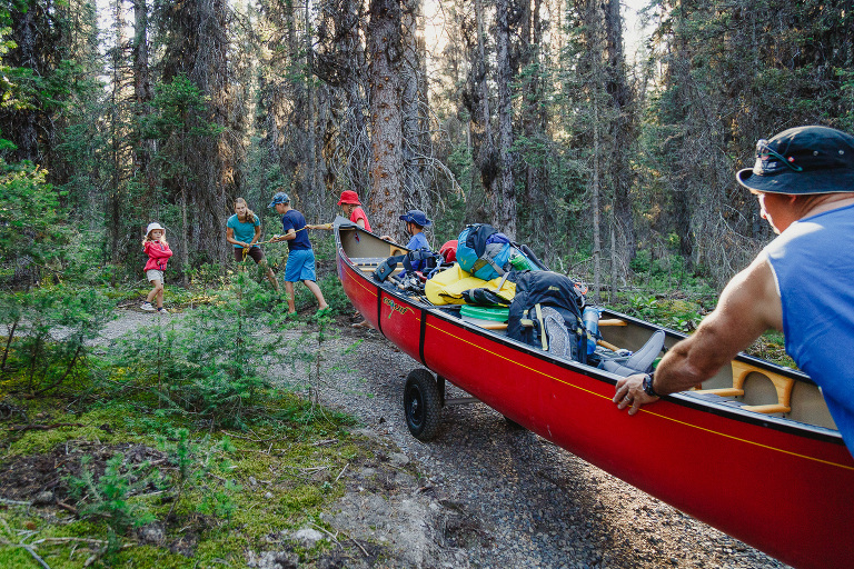 family portaging a canoe